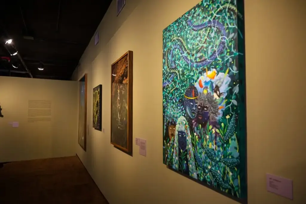 Parede na cor ocre com quadros em exposição