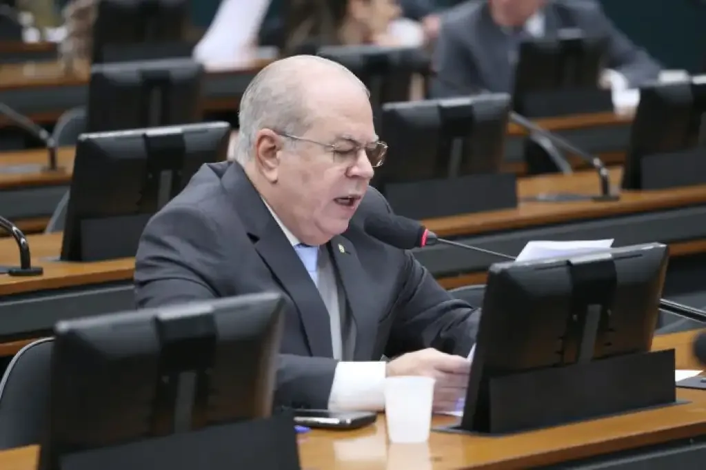 Deputado Hildo Rocha, sentado a mesa do parlamento olhando e lendo o papel.