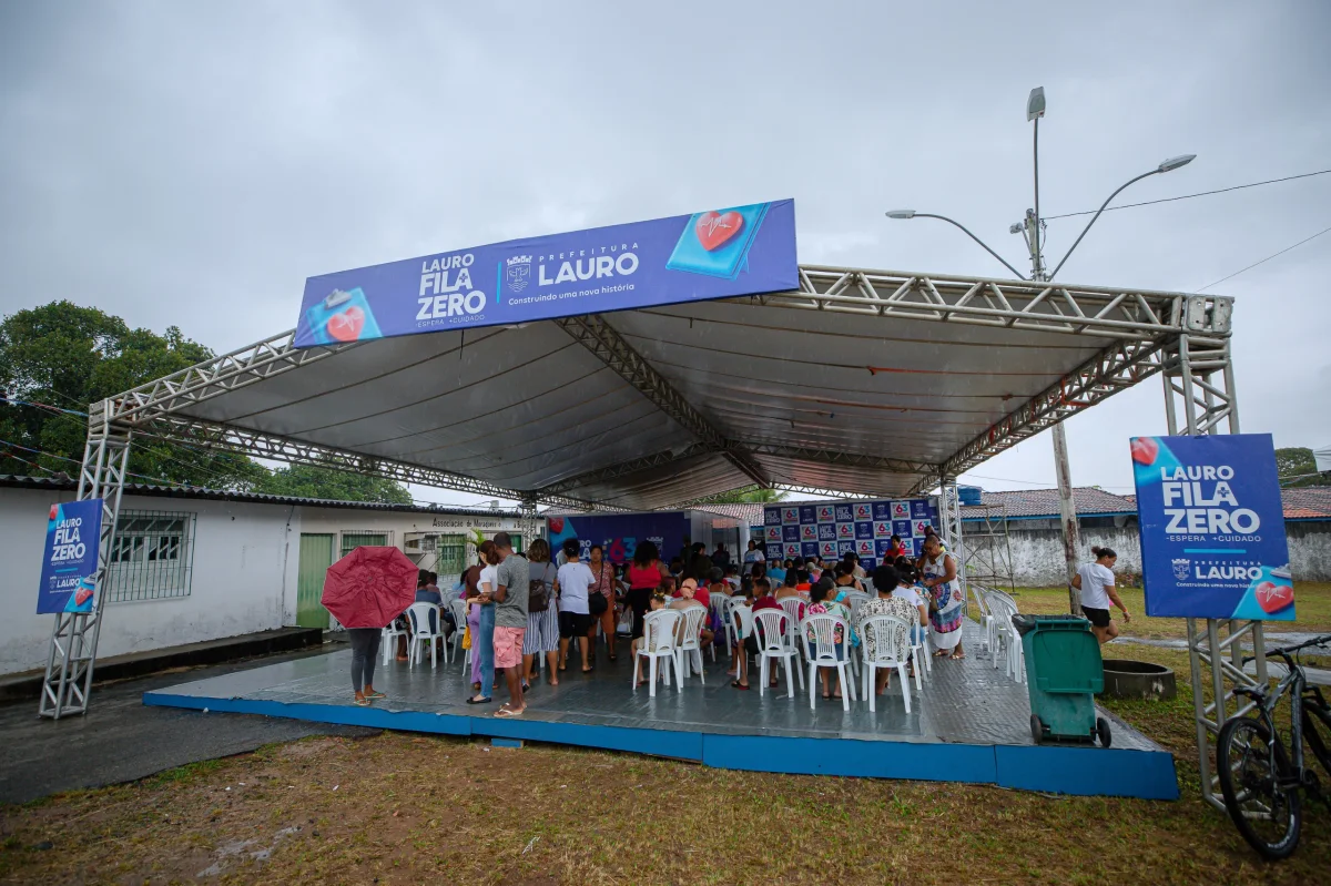Lugar coberto com pessoas sentadas em cadeiras brancas esperando a tendimento médico