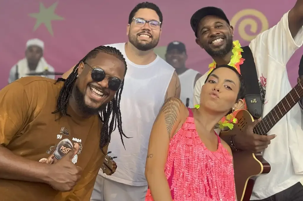 Três homes e uma mulher pousando para foto