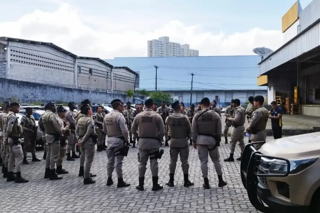 Policiais fardados fazento um enfileirados em circulo no pátio do batalhão de polícia