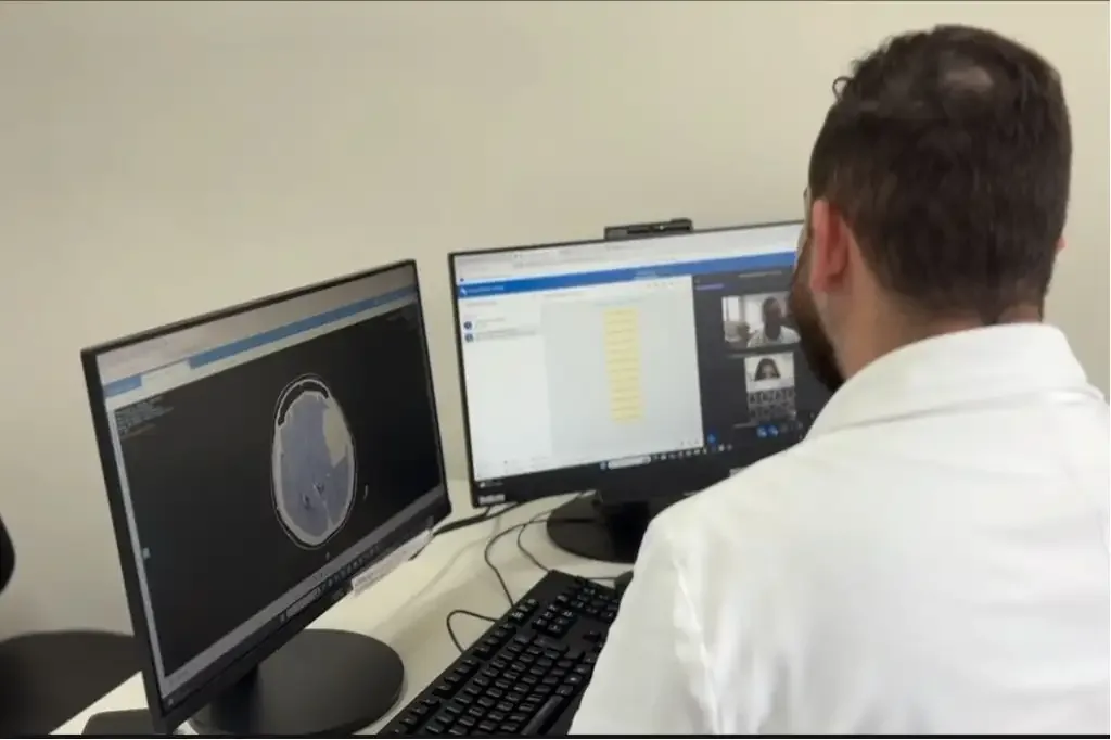 Homem de costas olhando para dois monitores