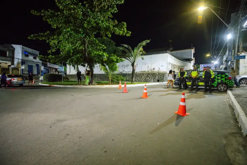 Rua a noite com guarda olhando o carro