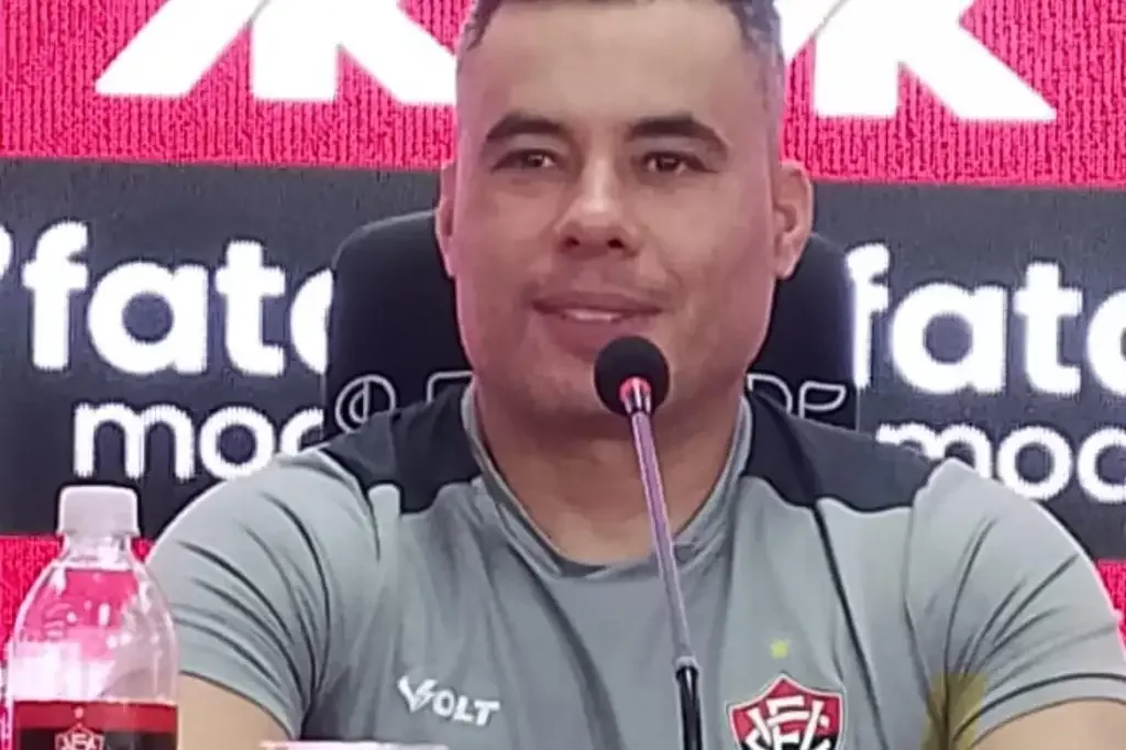 Homem falado a o microfone em uma coletiva esportiva