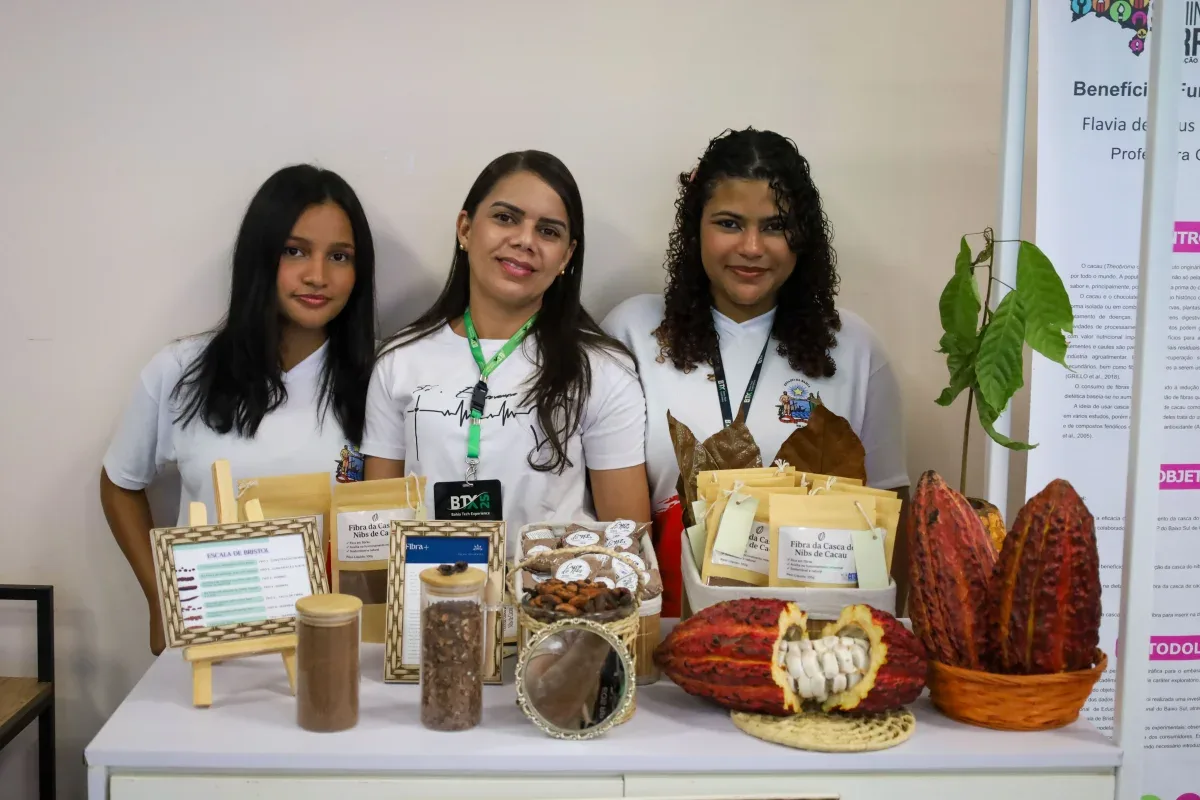 Três menisas estudantes apredentando projeto de fibra natural contra prisão de ventre