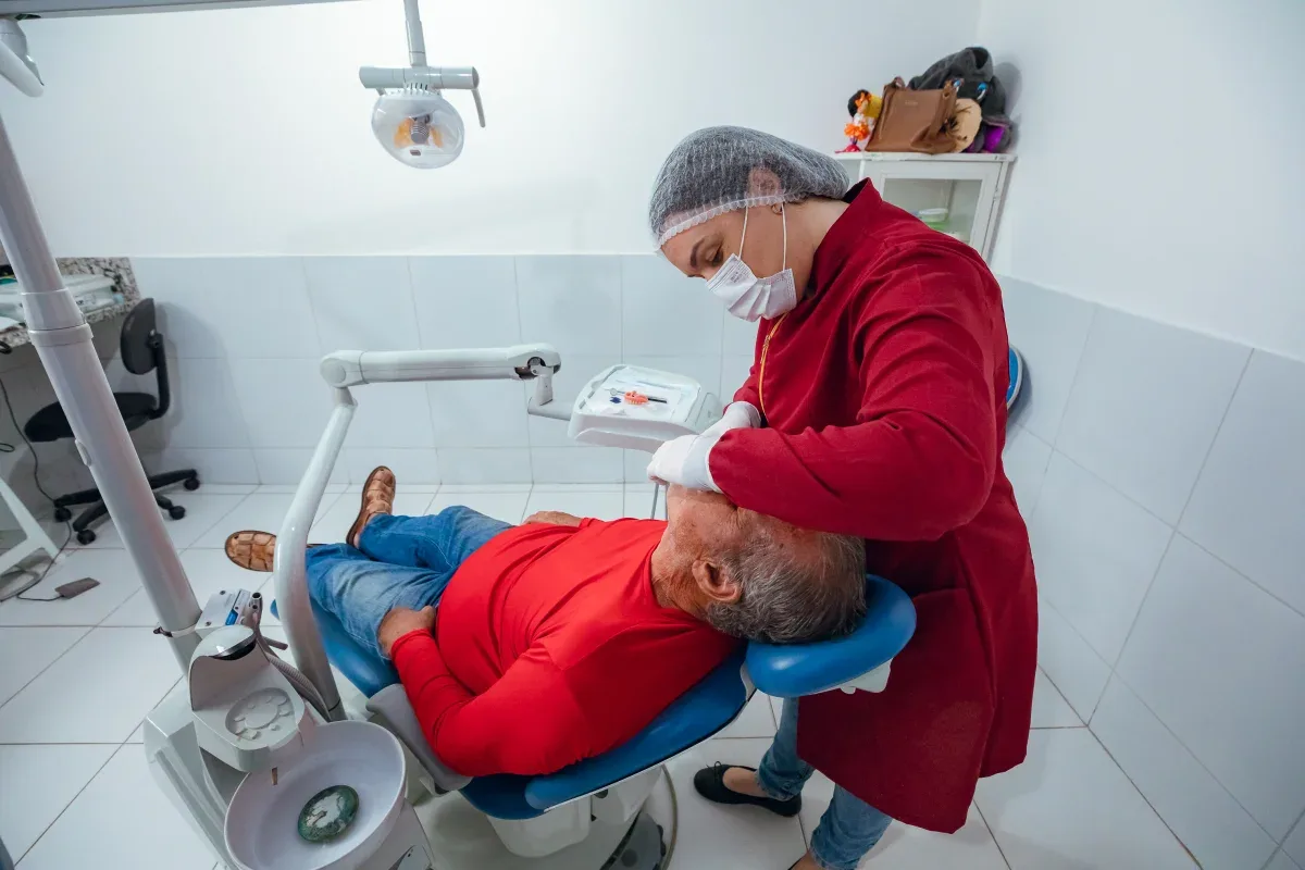 Dentista olhando a boca do paciente