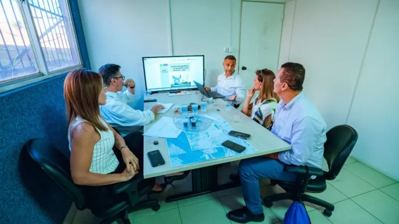 Cinco pessoas em uma sala em reunião