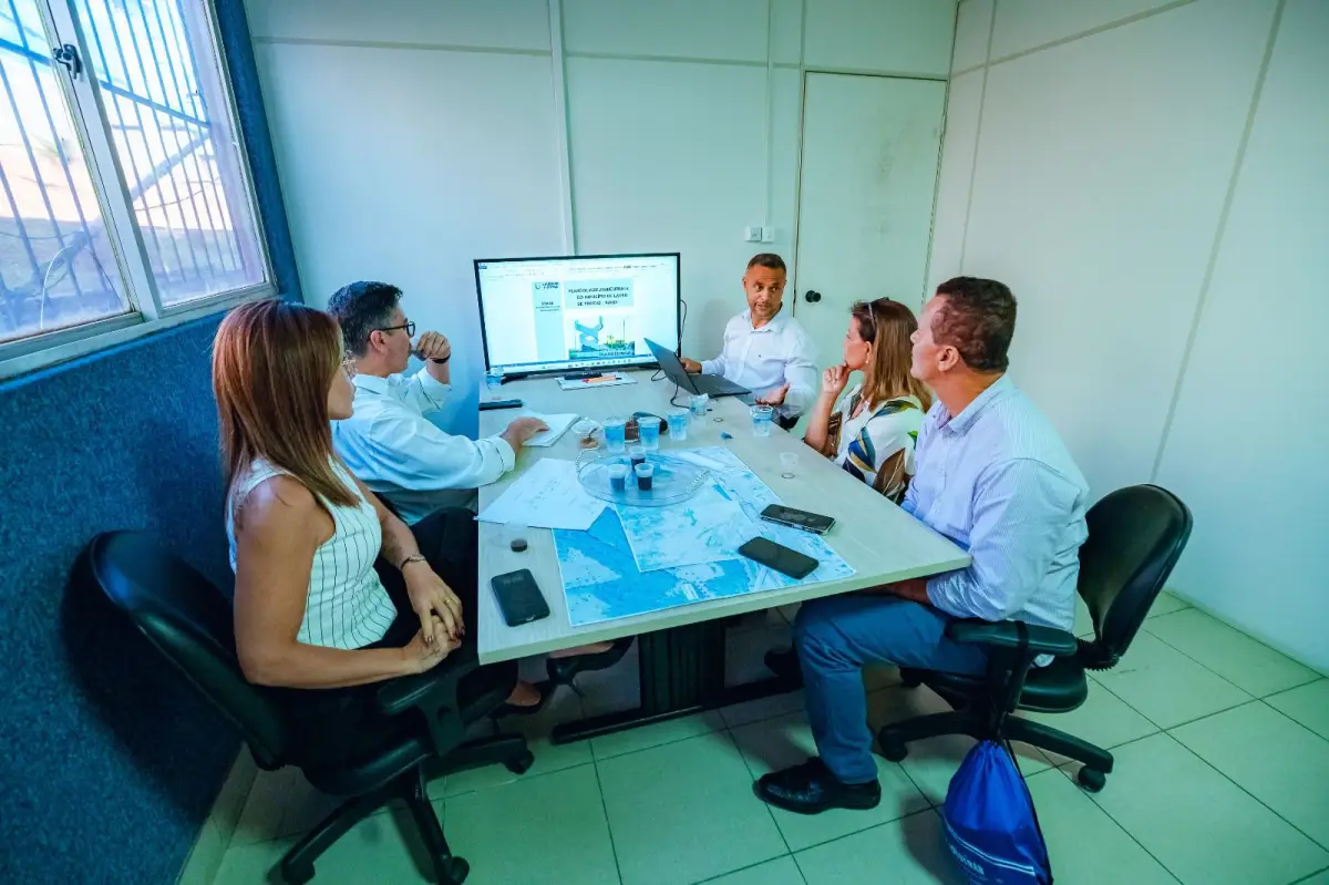 Cinco pessoas em uma sala em reunião