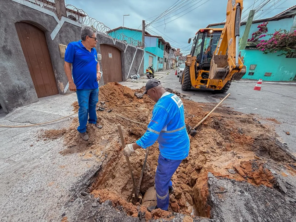 2 trabalhadores fazendoserviço de manutenção de esgoto na rua