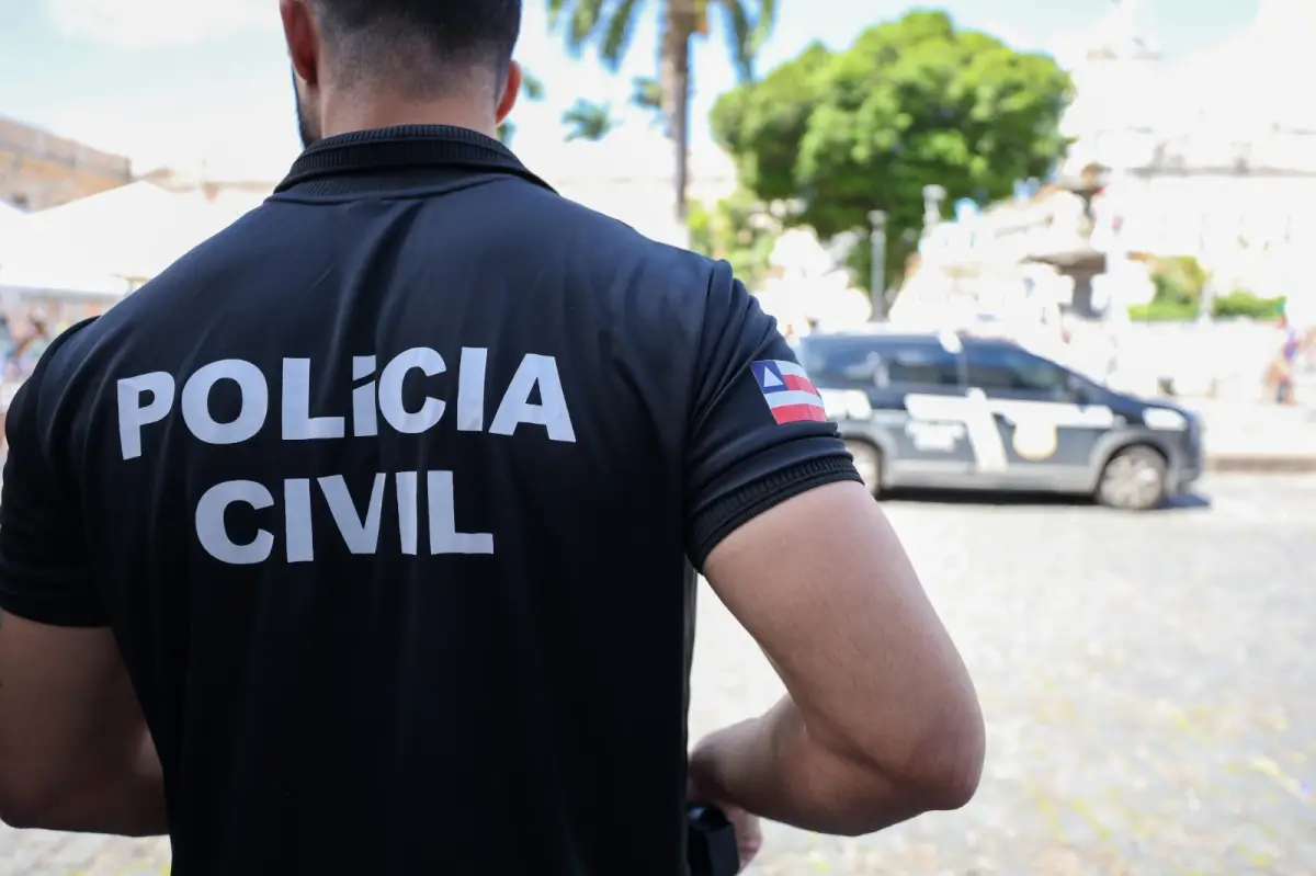 Policial Civil de costas na rua