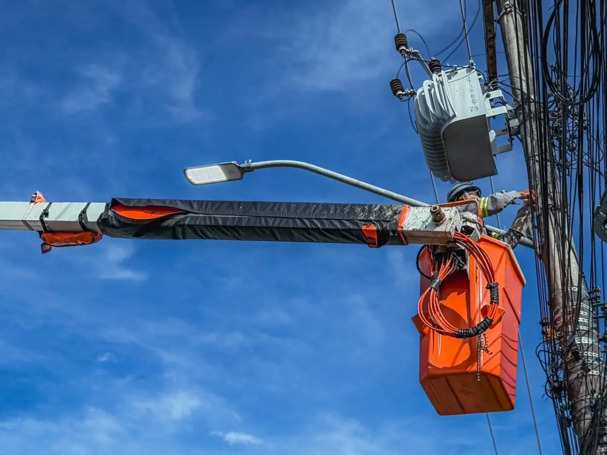 trabahador fazendo instalação de lâmpadas em postes