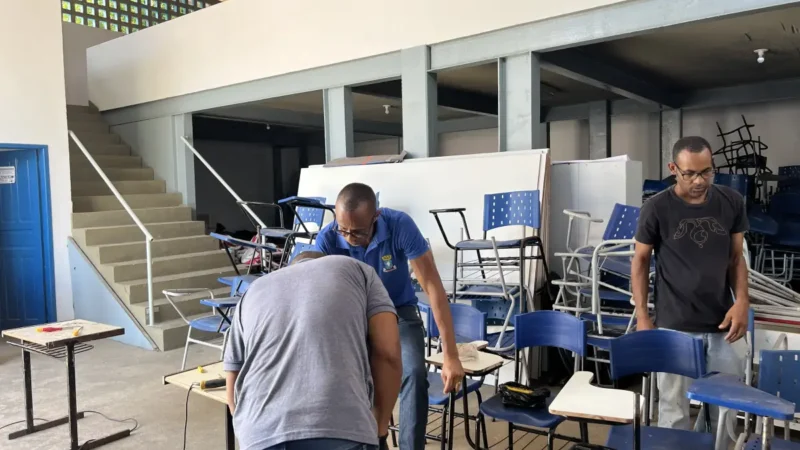 Homens consertando carteiras escolares