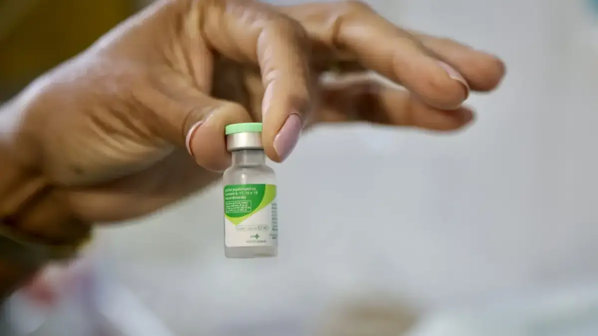 mão segurando franco de vacina contra o HPV