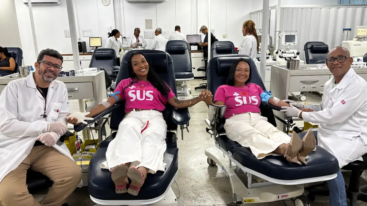 duas mulheres doando sangre e dois enfermeiros