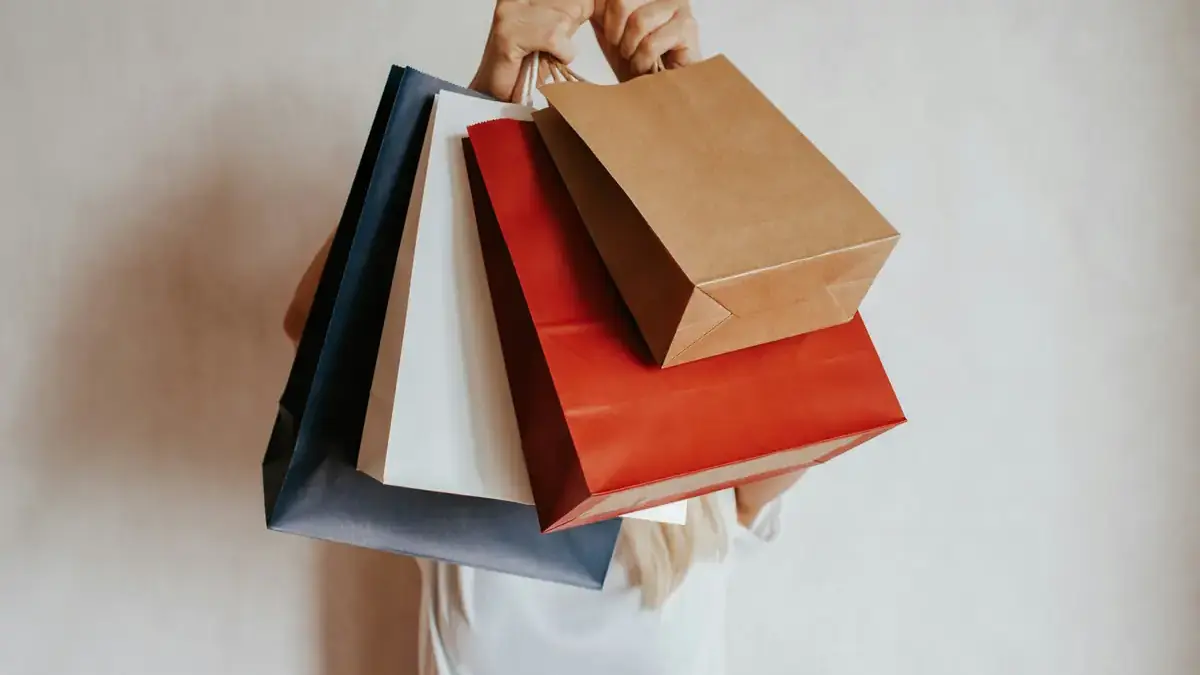 pessoa segurando sacolas de compras
