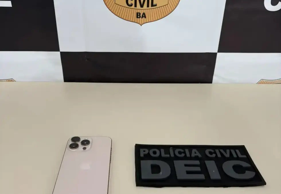 Agente da Polícia Civil segurando celular recuperado em Jequié, Bahia, durante operação de repressão a furtos.