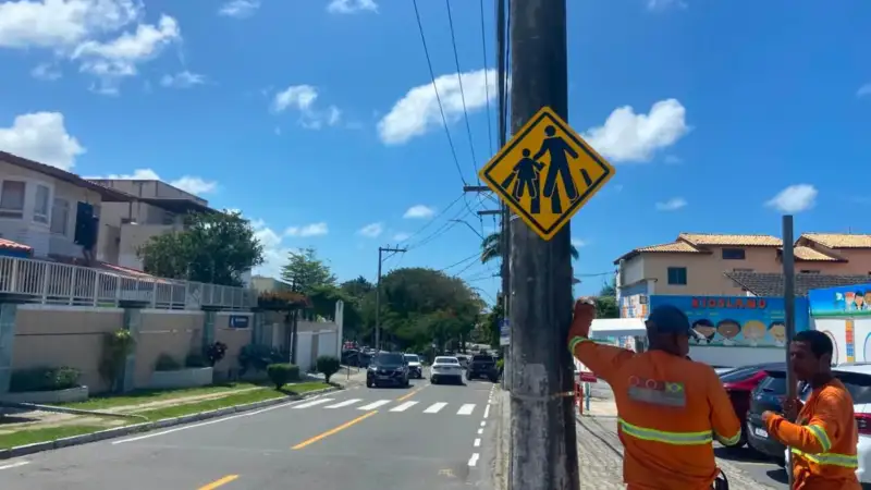 profissionais instalando placas de sinalização em Lauro de Freitas